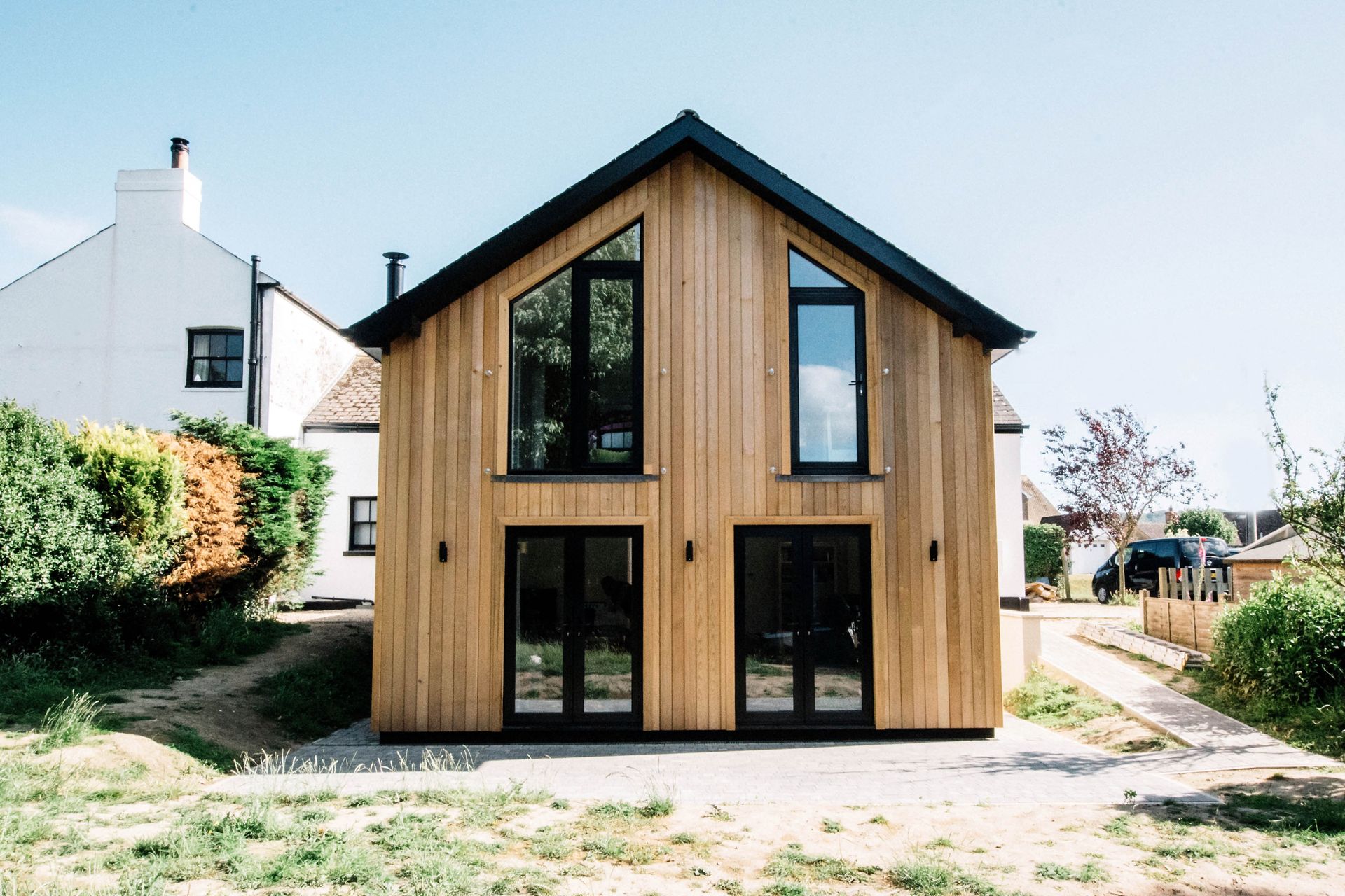 A house with a balcony and a blue sky in the background in a Large-Scale Retrofitting in Rye