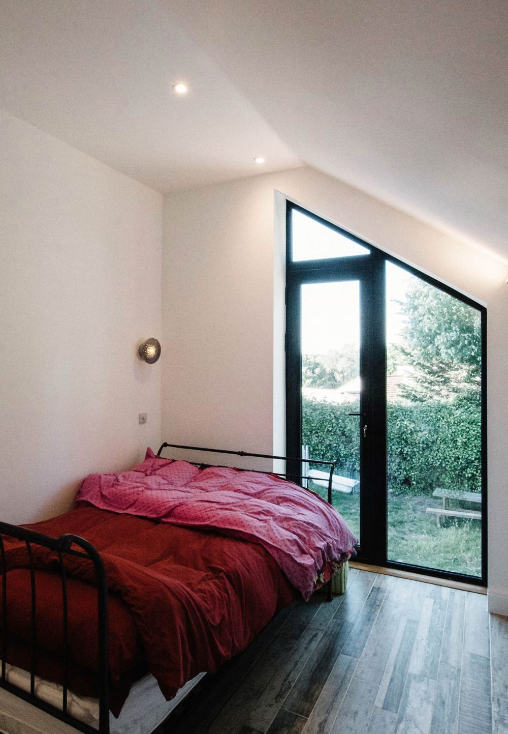 A bedroom with a bed and a large window in a Large-Scale Retrofitting in Rye