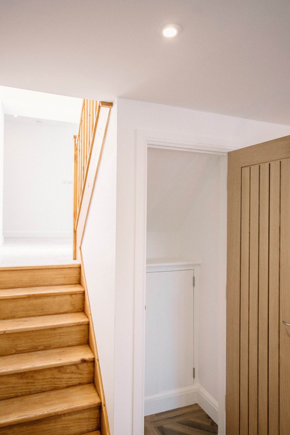 A wooden staircase leading up to the second floor of a house in a Large-Scale Retrofitting in Battle