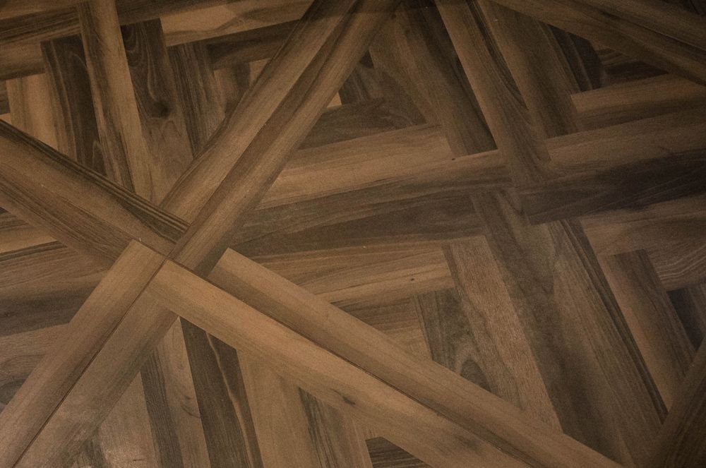 A close up of a wooden floor with a geometric pattern in a Large-Scale Retrofitting in Hastings