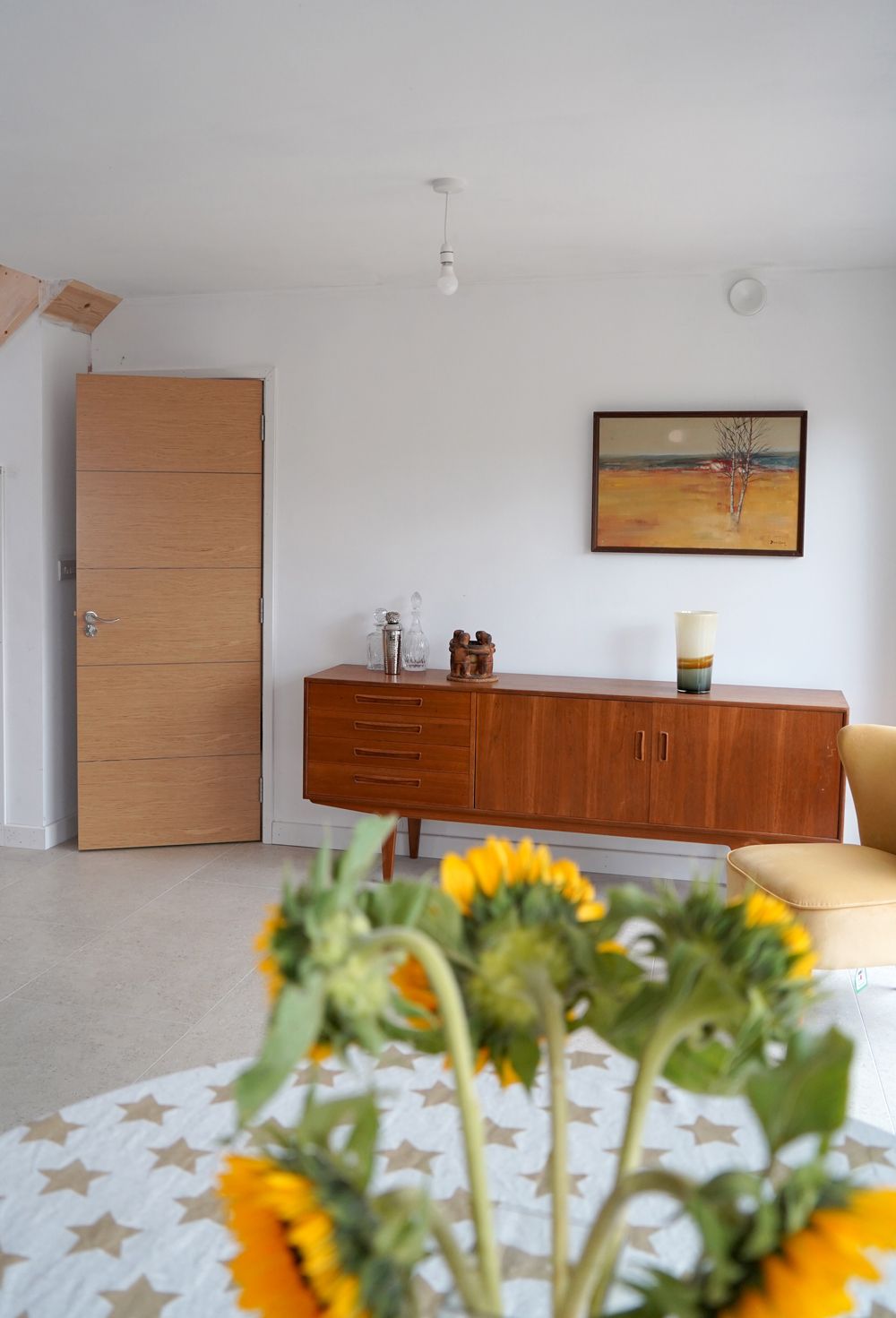 A vase of sunflowers sits on a table in a living room  in a Construction Management in East Sussex