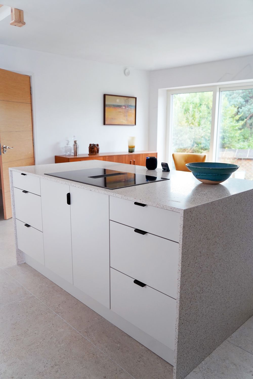 A kitchen with white cabinets and a bowl on the counter  in a Large-Scale Retrofitting in East Sussex