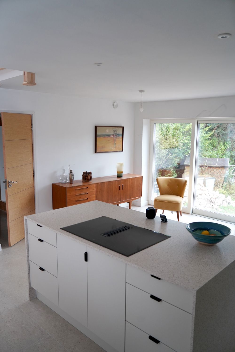 A kitchen with a large island and a stove top oven  in a Large-Scale Retrofitting in East Sussex
