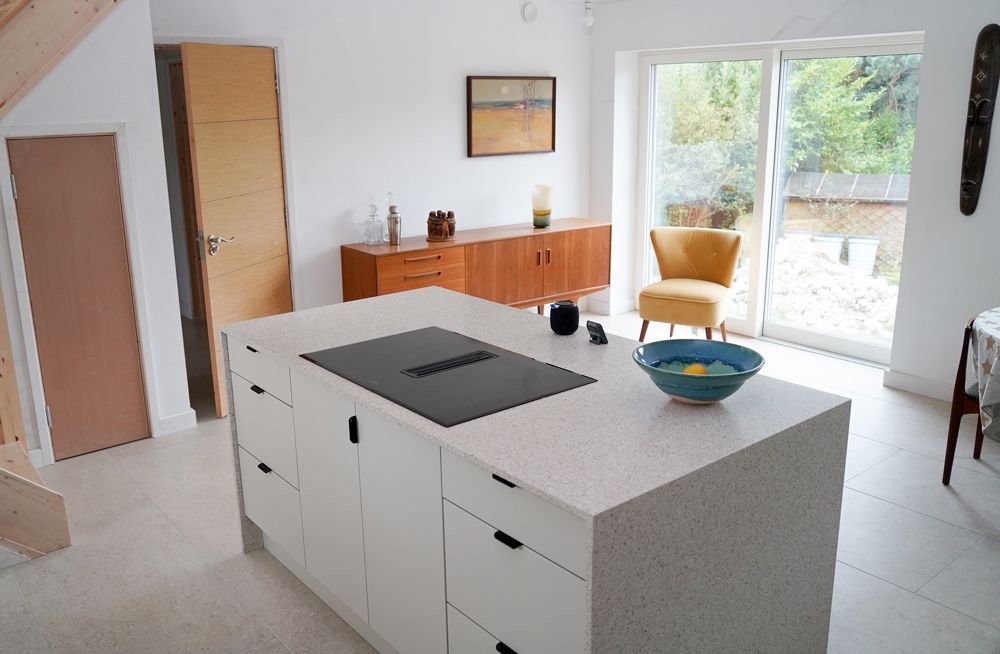 A kitchen with a large island and a stove top oven  in a Large-Scale Retrofitting in East Sussex