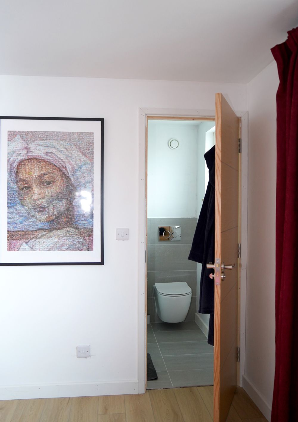 A bathroom with a toilet and a picture on the wall  in a Construction Management in East Sussex