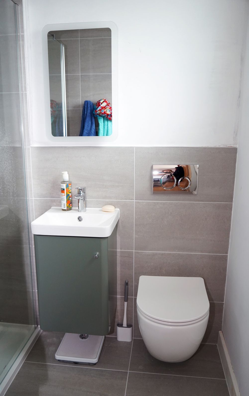 A bathroom with a toilet , sink and mirror  in a Large-Scale Retrofitting in East Sussex