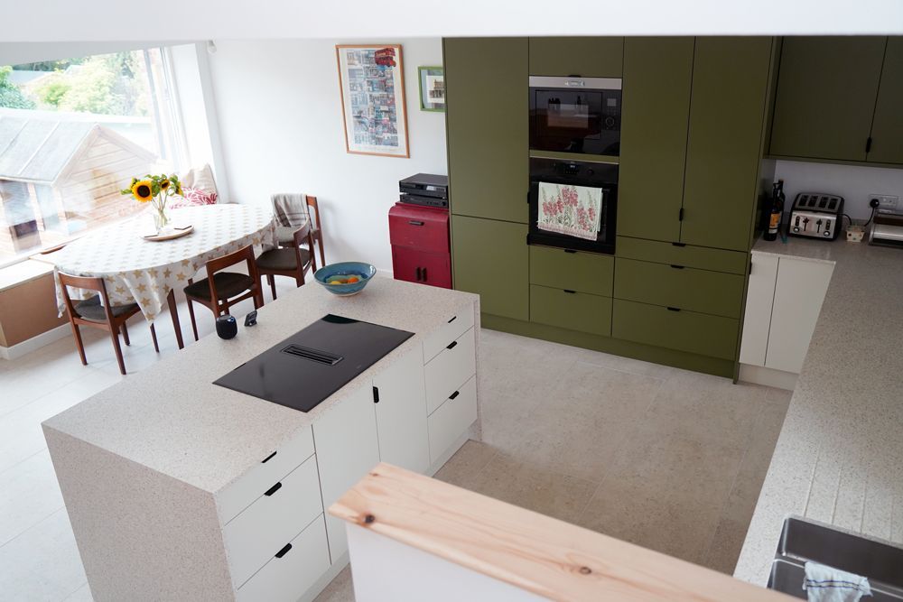 An aerial view of a kitchen with green cabinets and white cabinets  in a Large-Scale Retrofitting in East Sussex