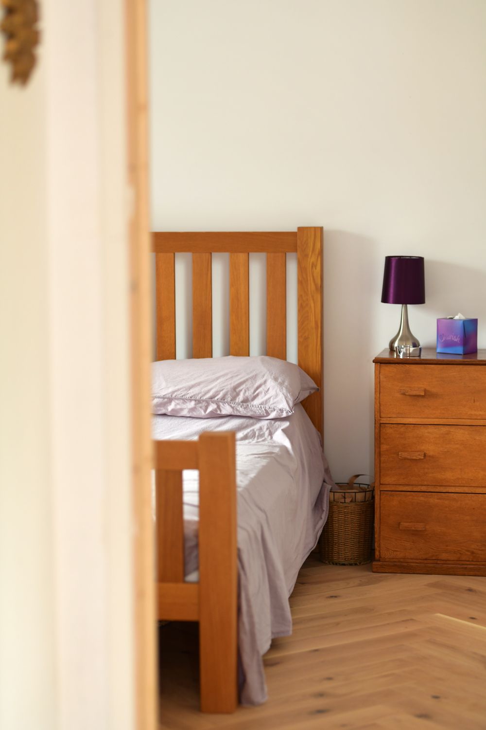 A bedroom with a wooden bed and a purple lamp  in a Retrofit Consultancy in East Sussex