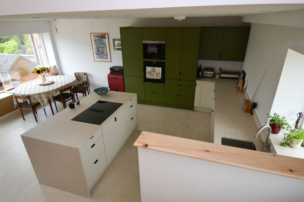 An aerial view of a kitchen with green cabinets and white cabinets  in a Passivhaus New Builds in East Sussex