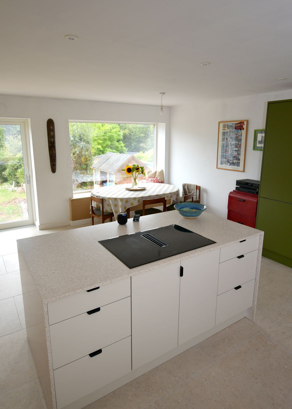 A kitchen with white cabinets and a large island with a stove top oven  in a Passivhaus New Builds in East Sussex