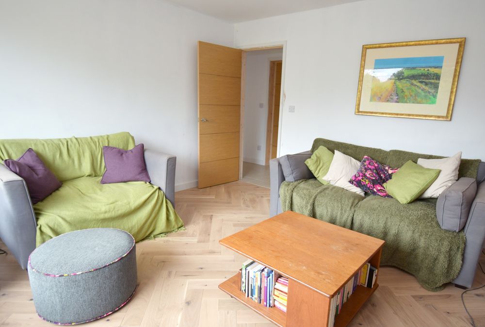 A living room with two couches , a coffee table , and a picture on the wall  in a Retrofit Consultancy in East Sussex