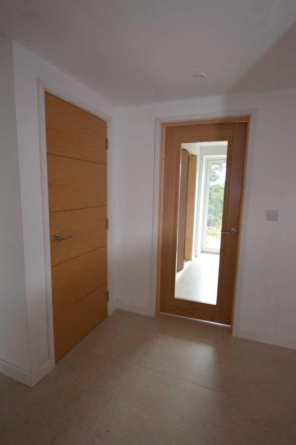 An empty room with a door and a mirror  in a Construction Management in East Sussex