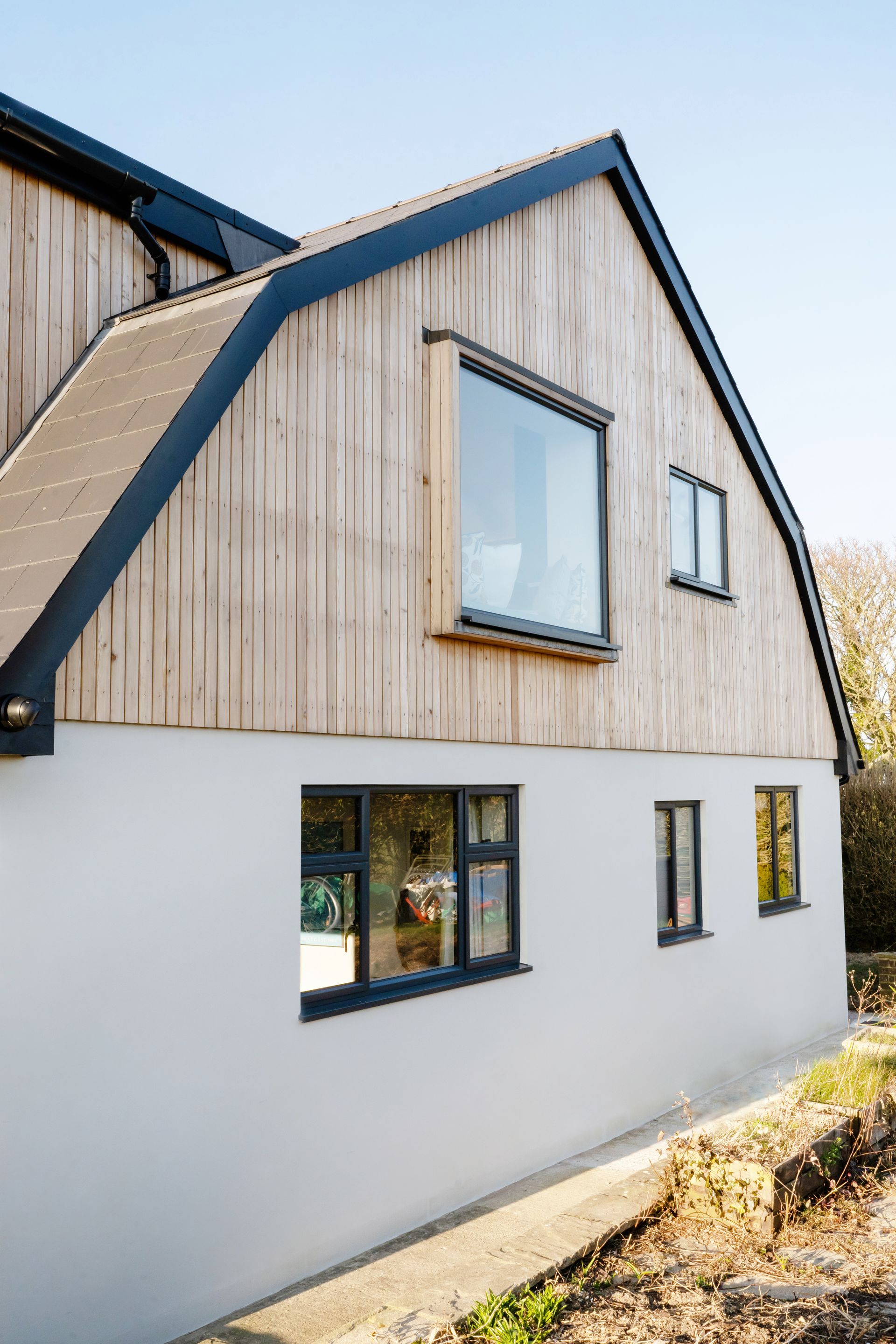 A house with a lot of windows and a brick roof  in a Passivhaus New Builds in East Sussex