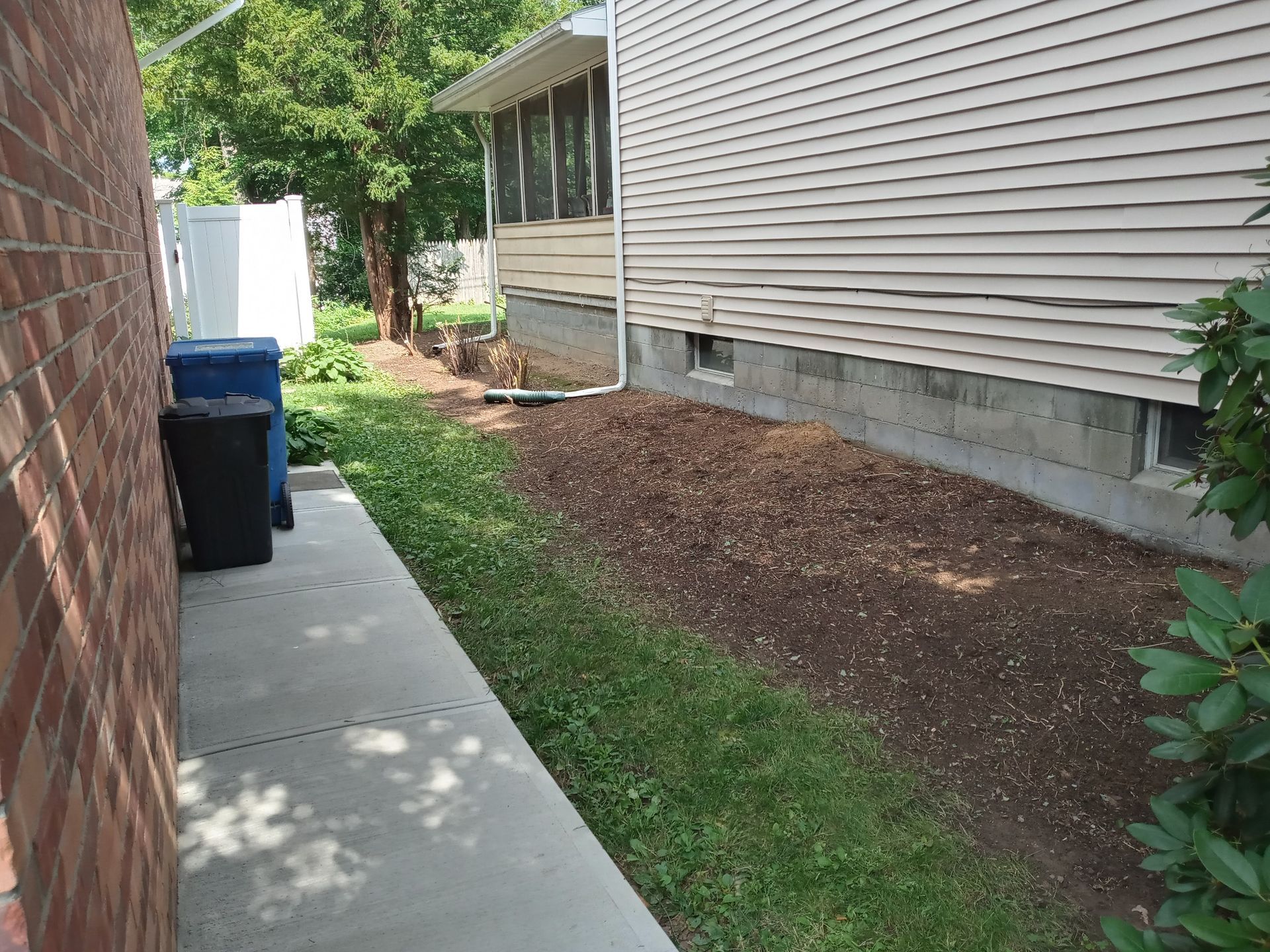 a sidewalk leading to a house with a brick wall