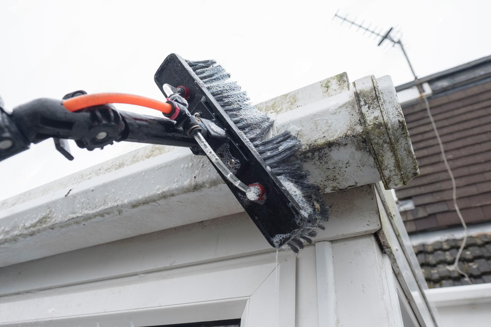 a person is cleaning a gutter with a brush .