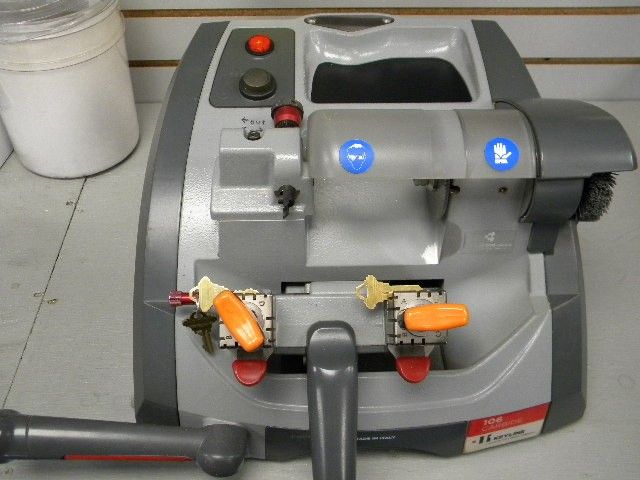 Key duplication machine with two keys secured in the clamps during the cutting process.