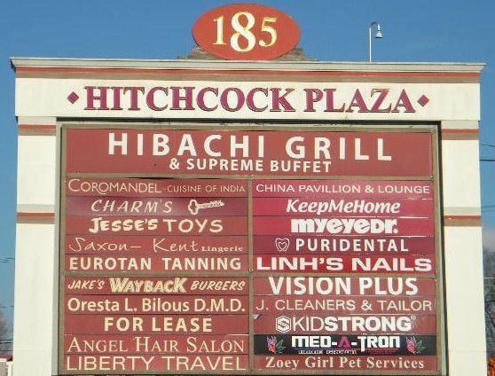 Hitchcock Plaza sign showing Charm’s Security Hardware sign on it.