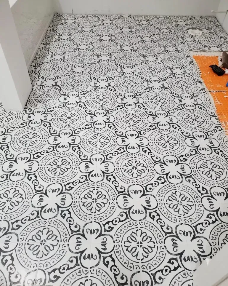 Black and white patterned tile floor in a room, partially installed.