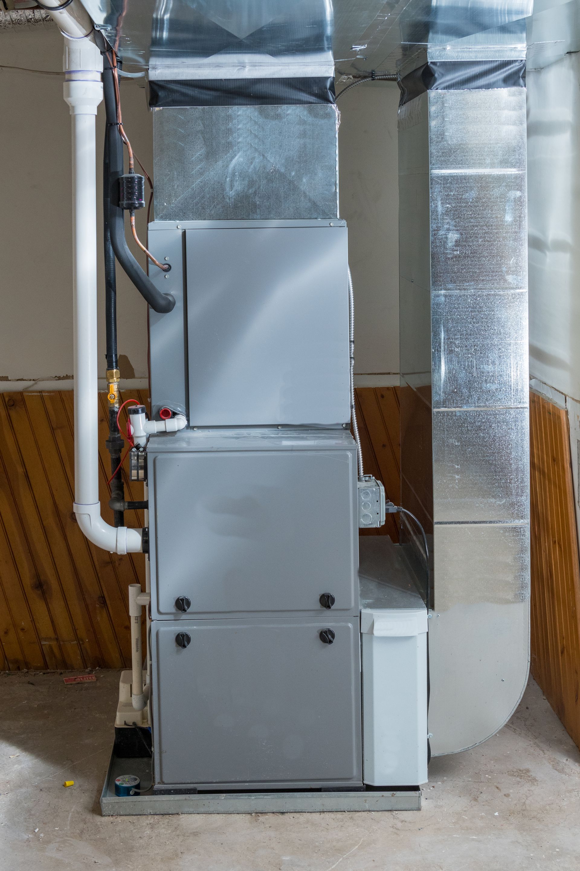An air conditioner is sitting in the basement of a house.