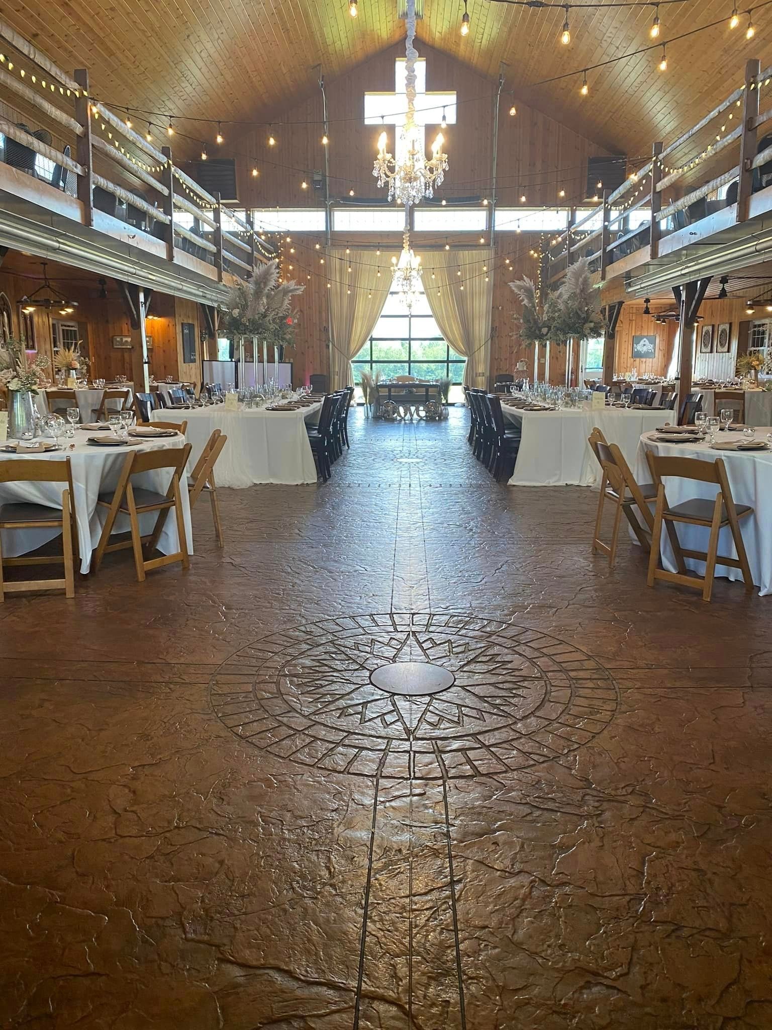 A large room with tables and chairs set up for a wedding reception.