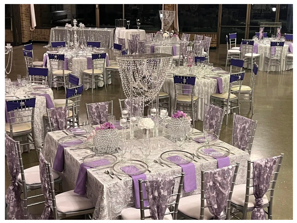 A large room with tables and chairs set up for a wedding reception.