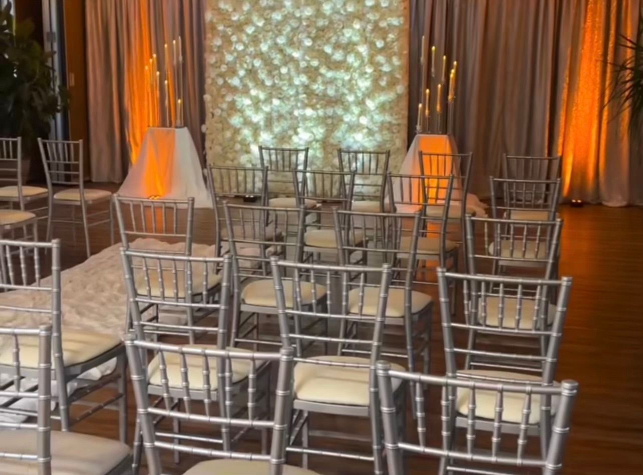 A row of silver chairs are lined up in a room.