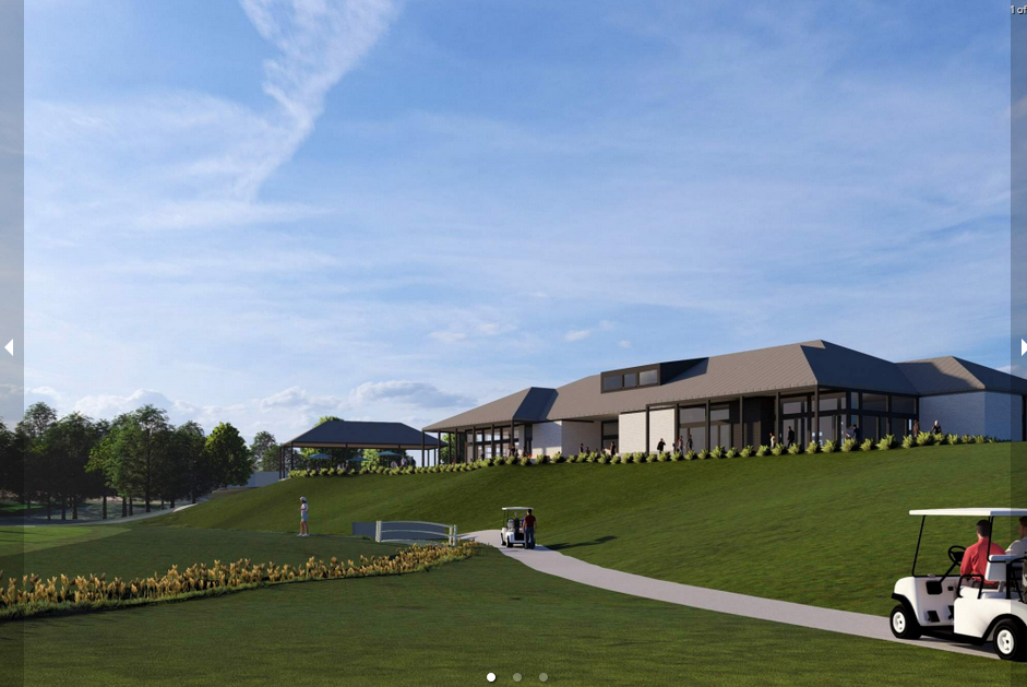 Golf course with clubhouse on a grassy hill. Golf carts on a path. Cloudy blue sky.