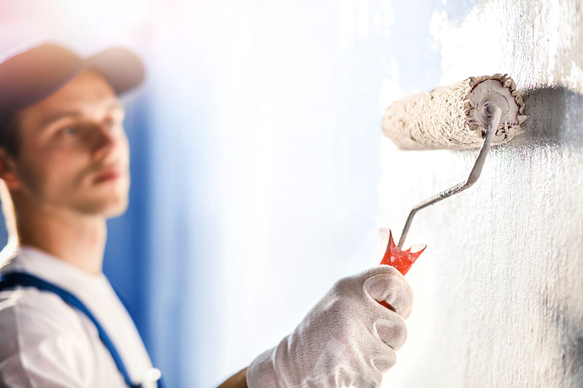 Professional painters applying white and blue paint on interior walls during home renovation.