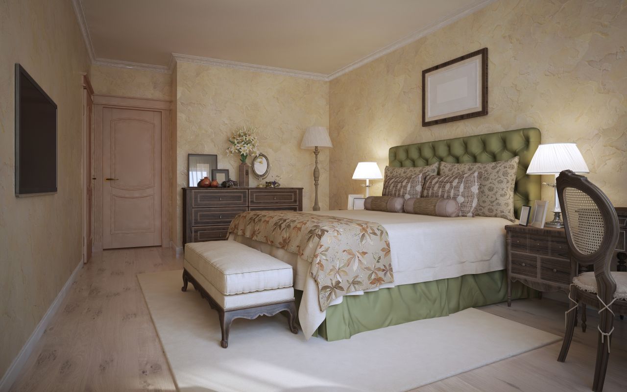 Interior of a home with arched doorways, warm yellow walls, wood floors, and potted plants.