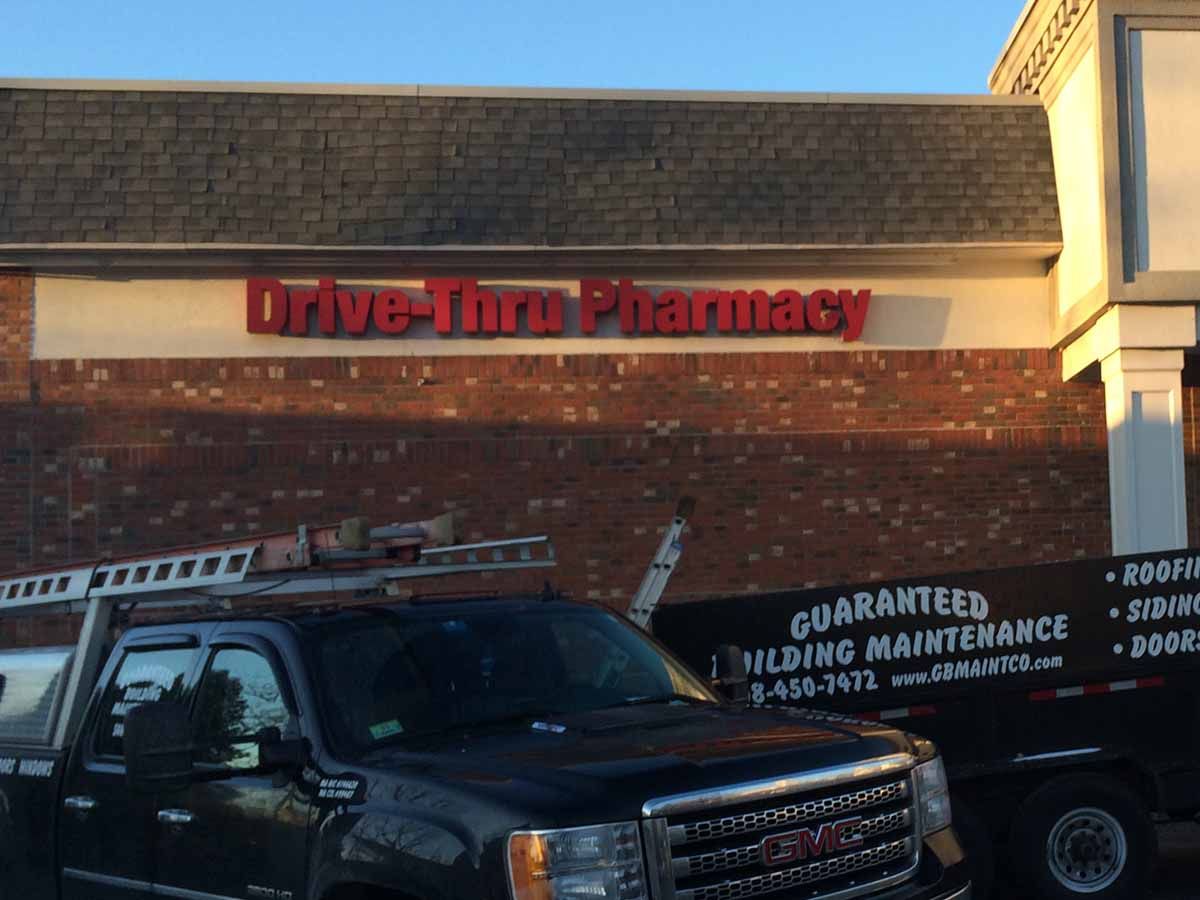 A black GMC truck parked in front of a brick building with a 