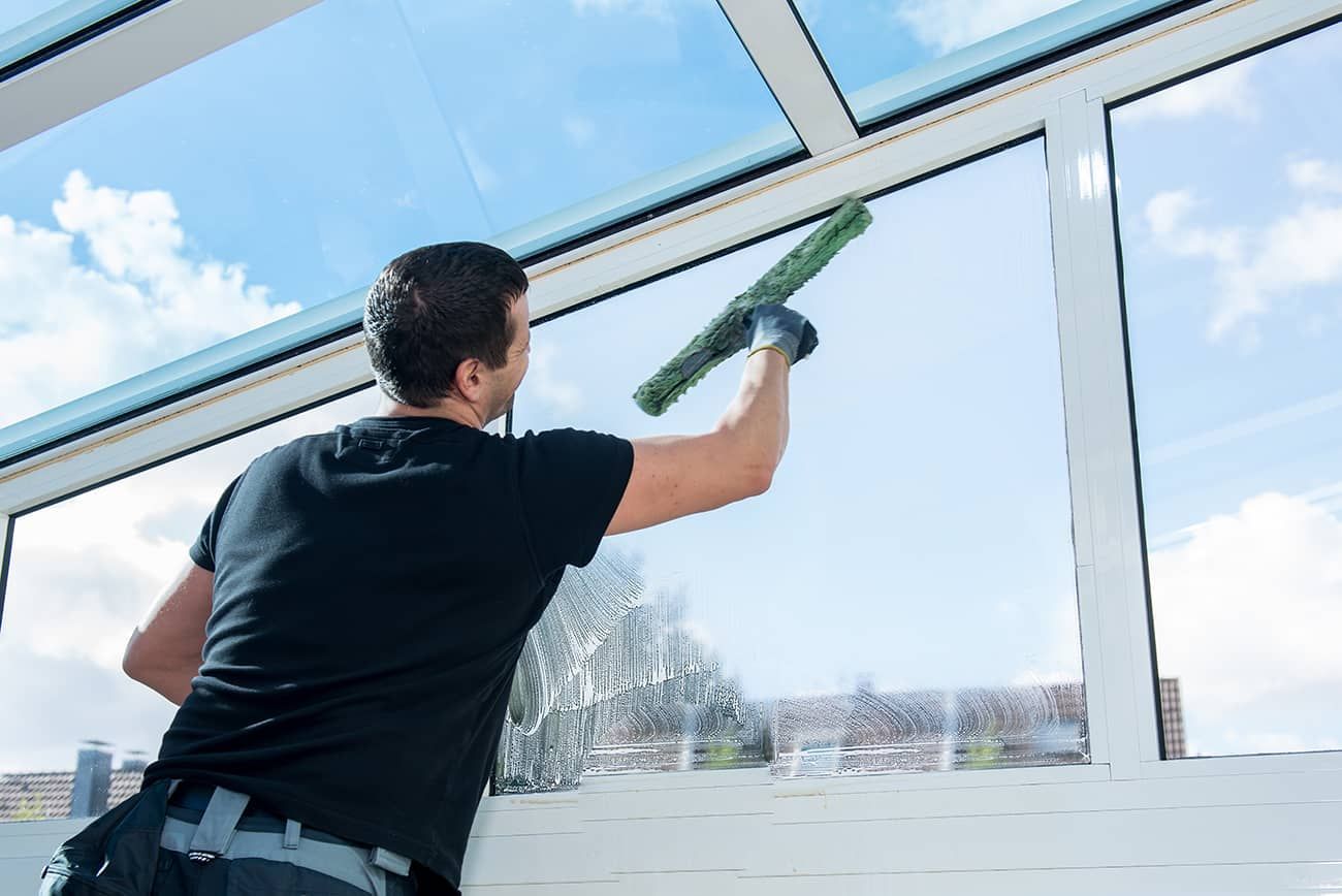 man is cleaning a window 