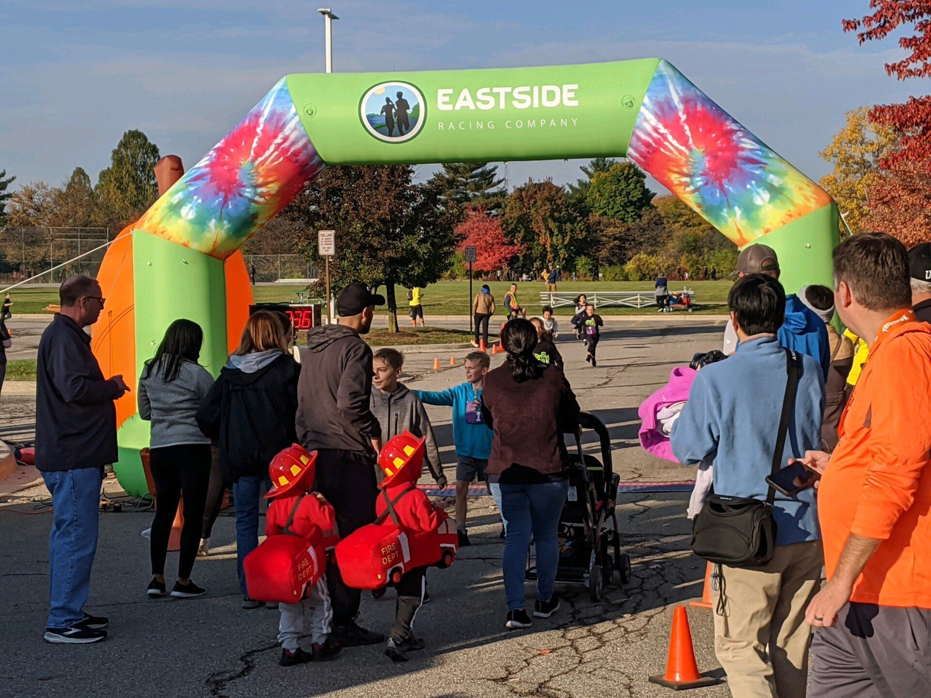 People at the starting line of the Eastside Culture Festival 5k. An inflatable archway marks the finish line; fall foliage visible.