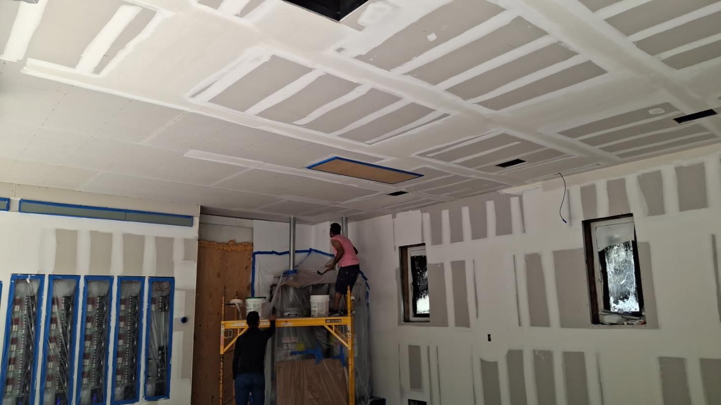an attic under construction with wooden beams and a window .