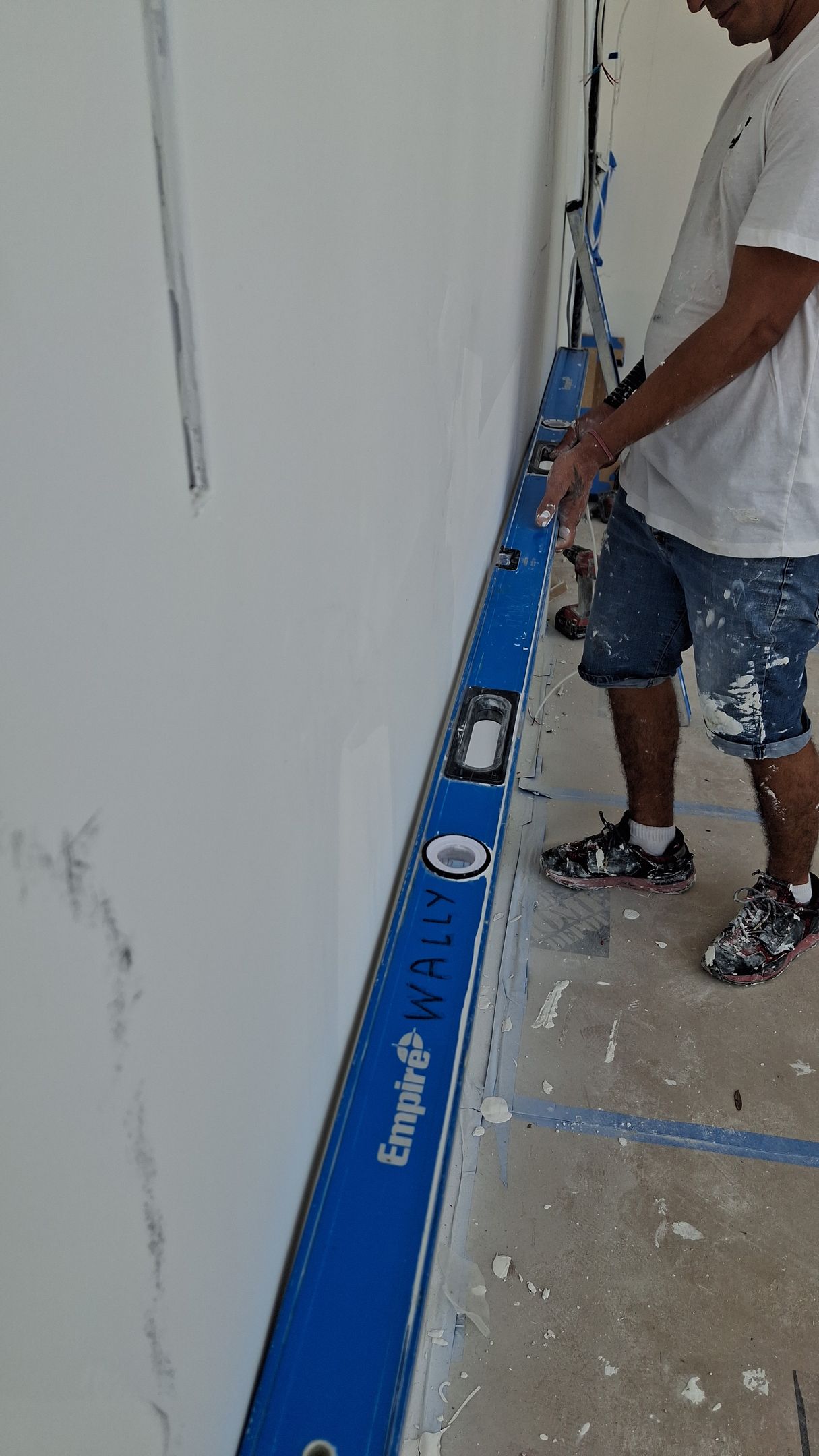 a man is measuring a wooden floor with a tape measure .