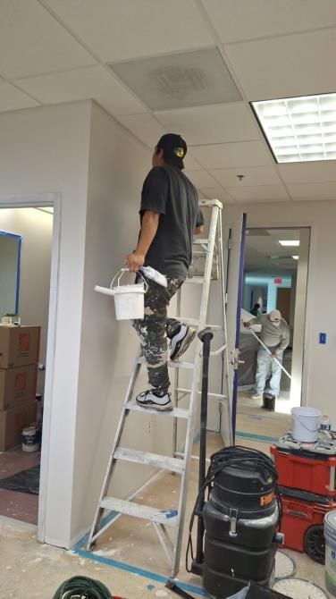 an empty room with a wooden floor and a ladder .