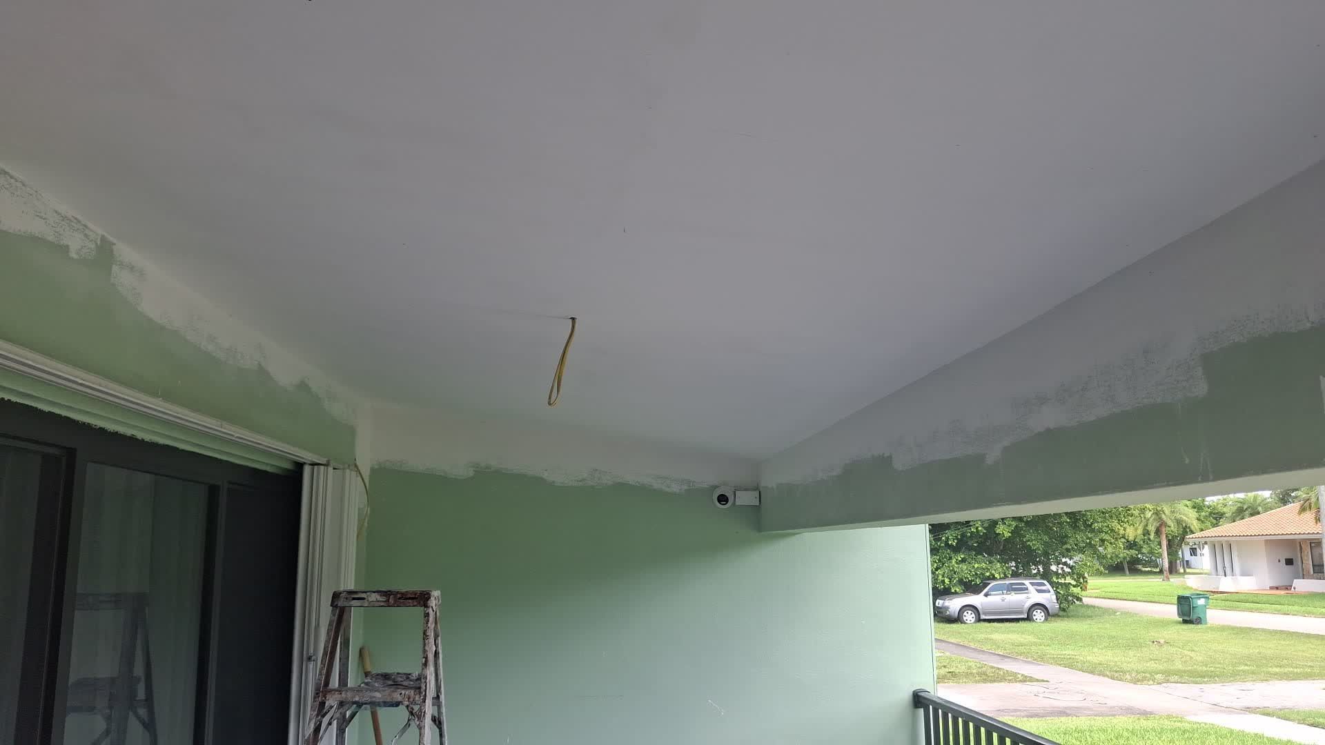 a person is painting a wall with a paint roller .