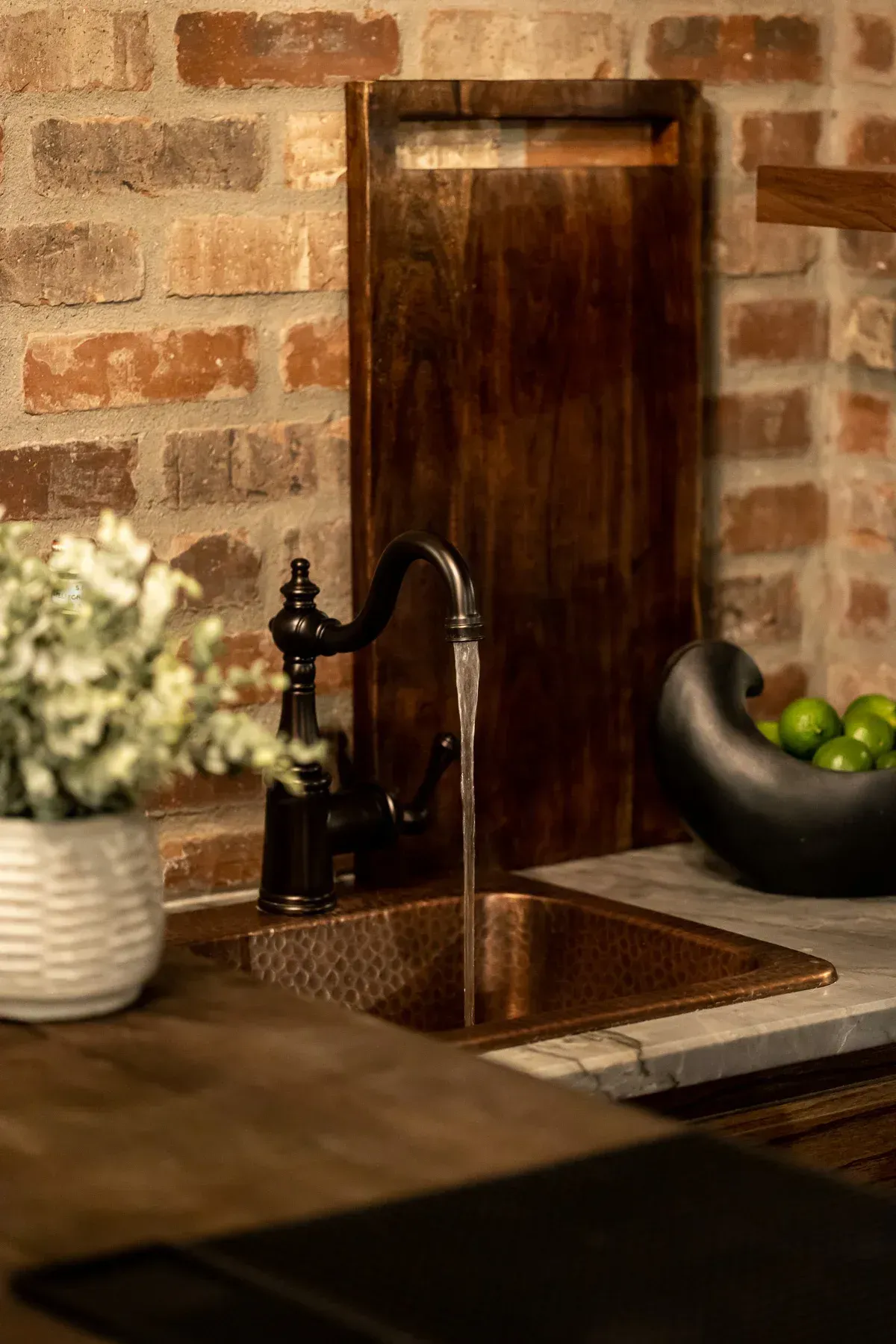 Black faucet with brick backdrop