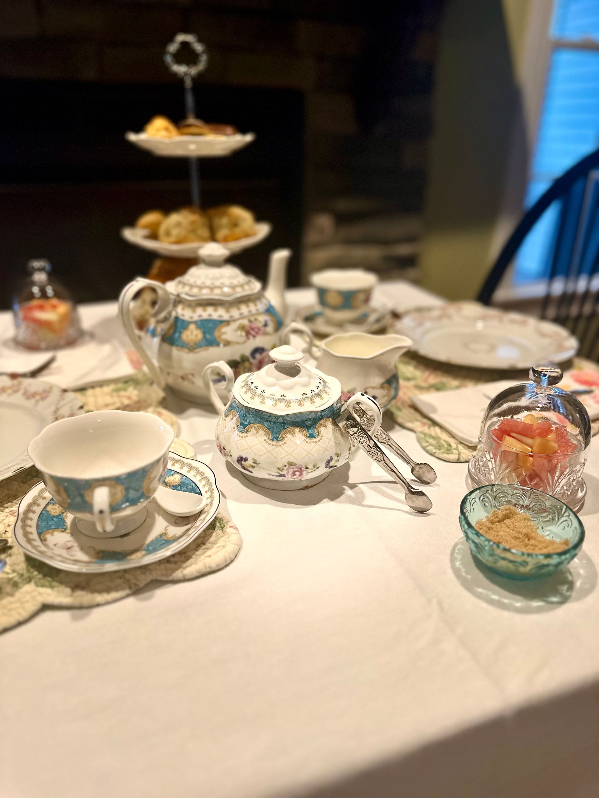 A table set for a tea party with a teapot , cups , saucers , and plates.