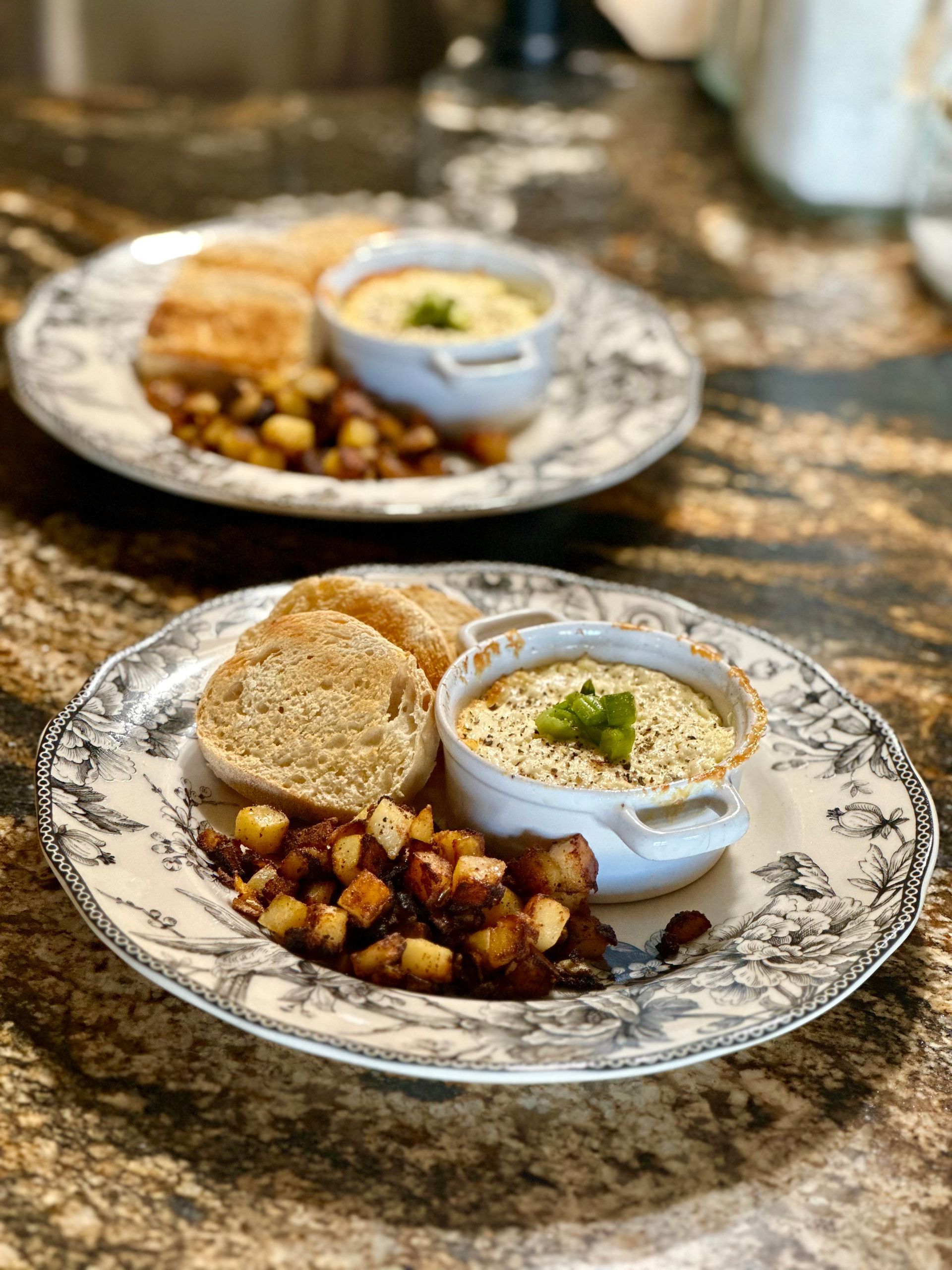 Two plates of food are sitting on a counter.