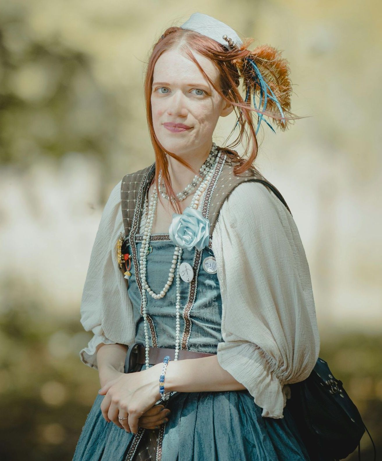 A woman in a blue dress is standing in a field.