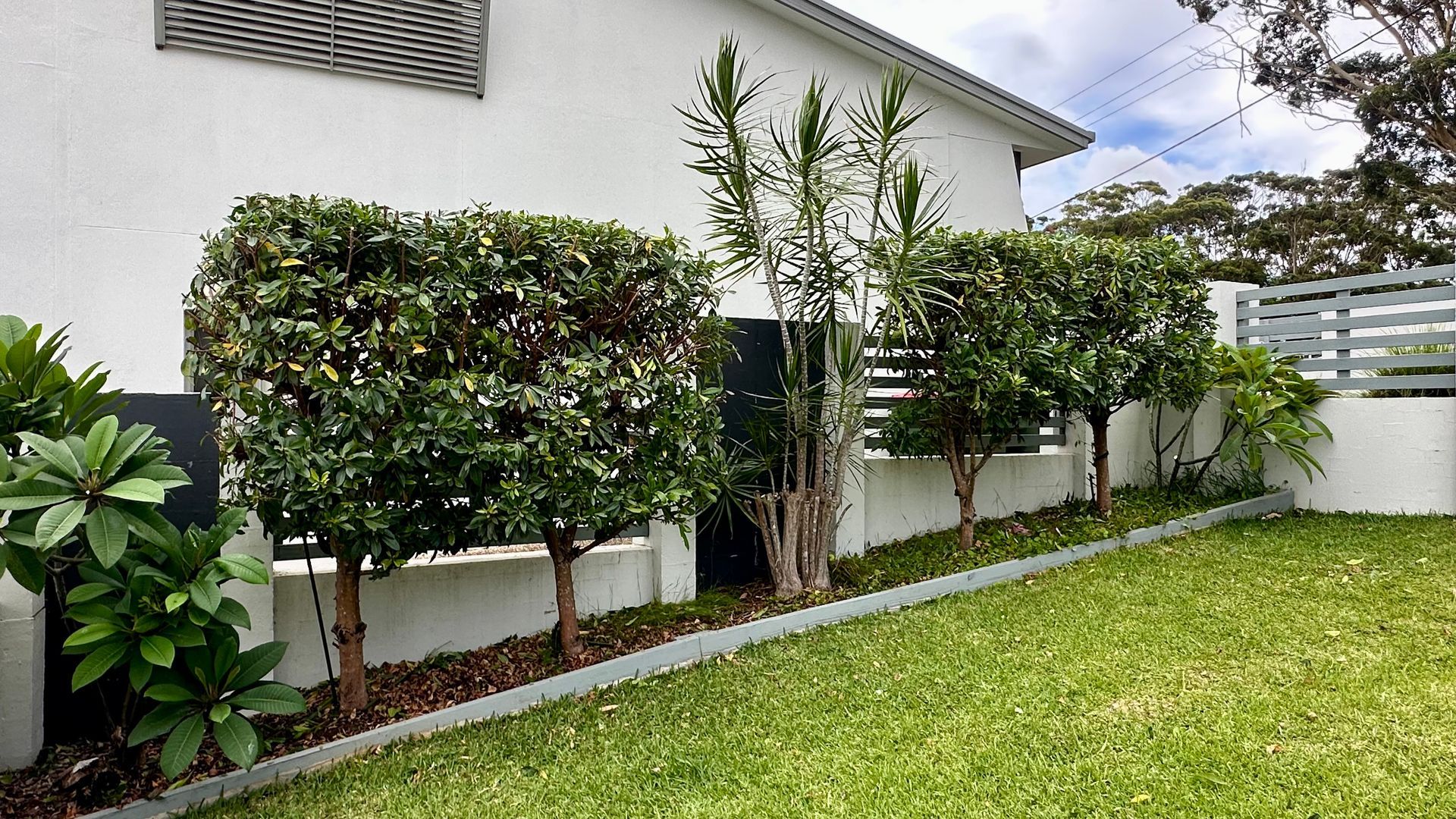 A Person Is Using A High Pressure Washer To Clean The Side Of A House — Tall Orders Port Macquarie In Port Macquarie, NSW 