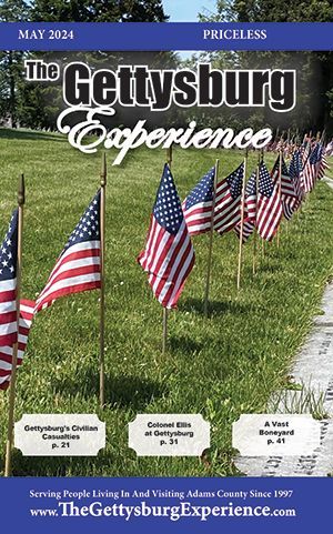 A row of American flags are lined up in a cemetery on the cover of The Gettysburg Experience May 2024 edition.