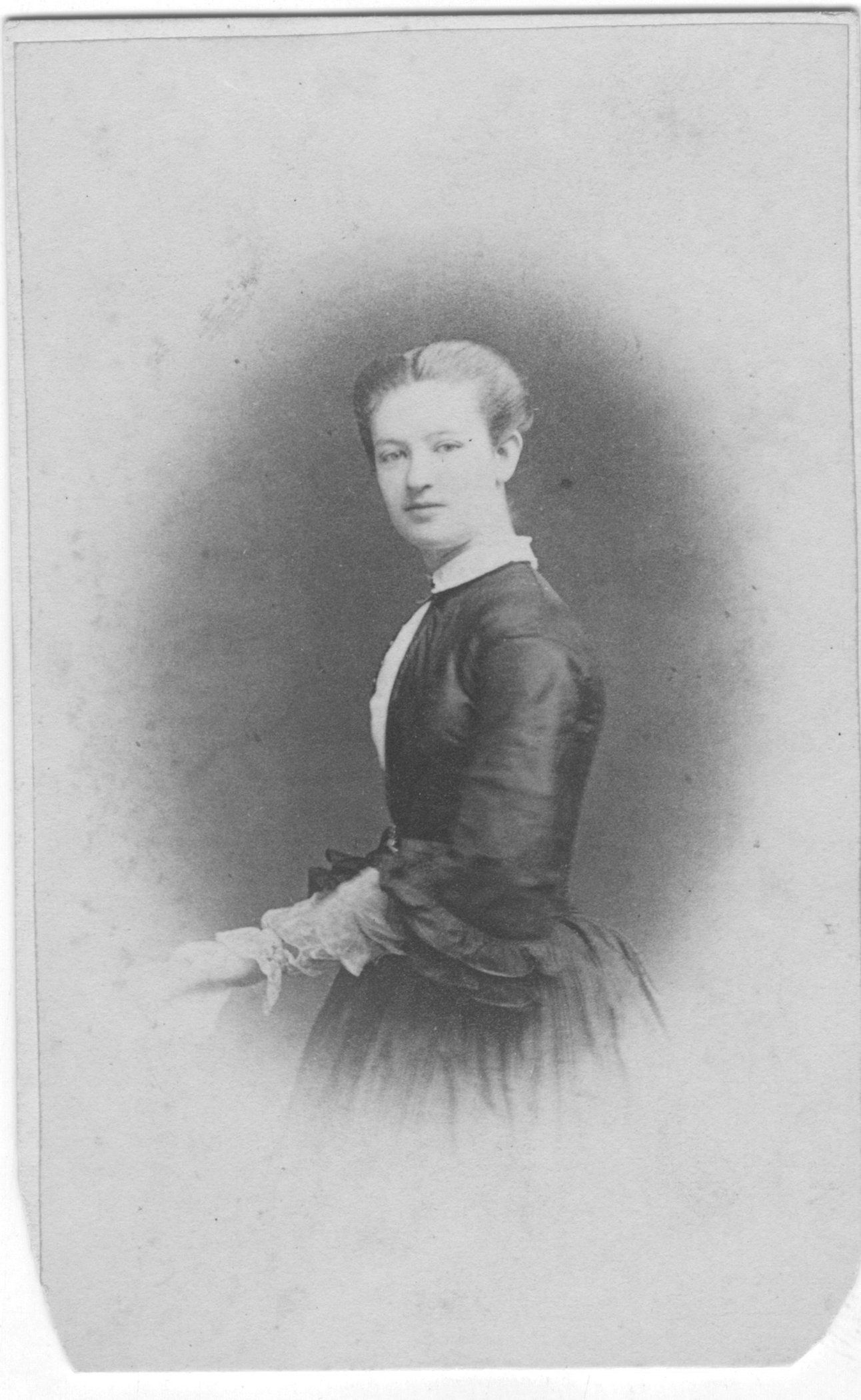 a black and white photo of a woman in a black dress .