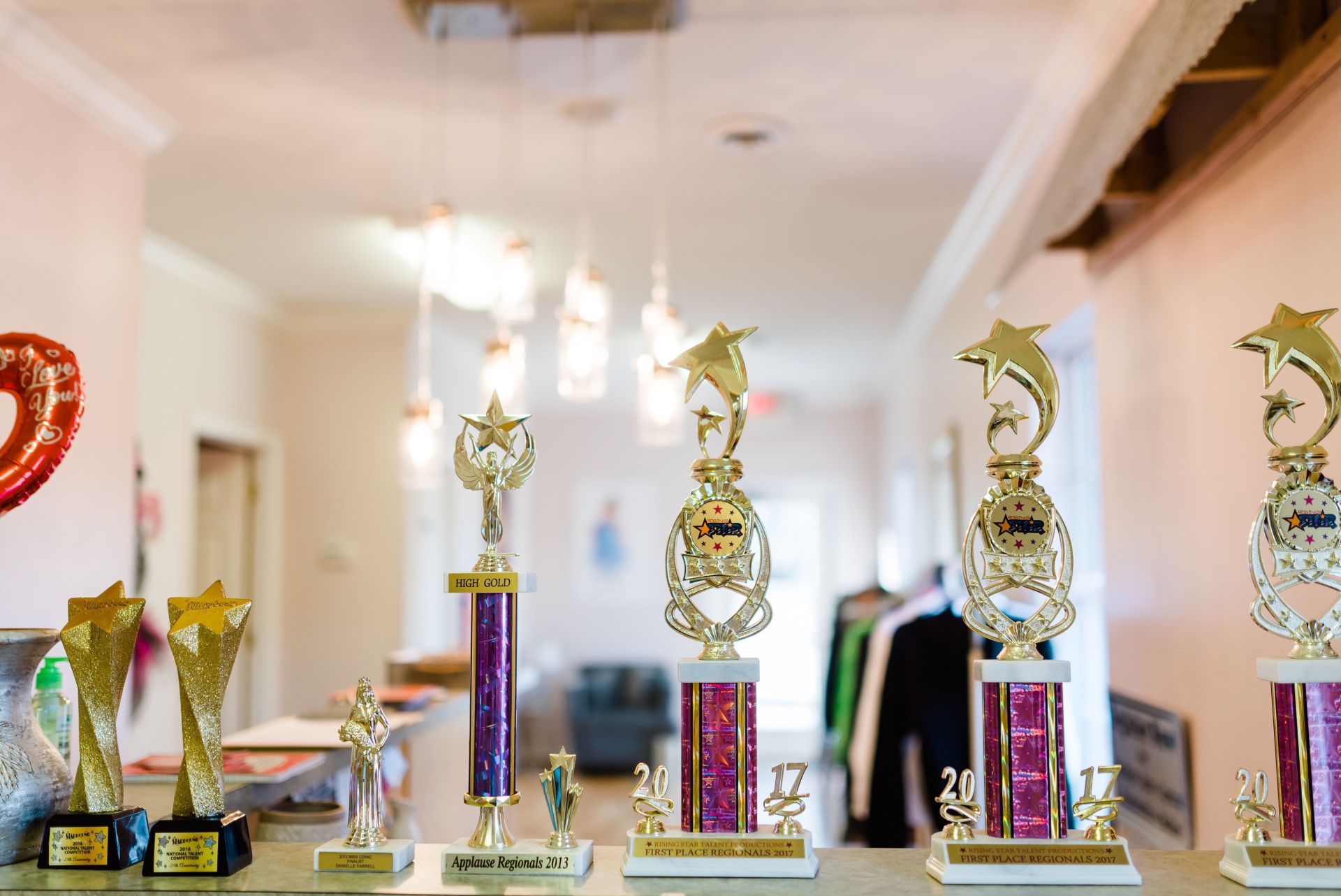 A bunch of trophies are on a table in a room