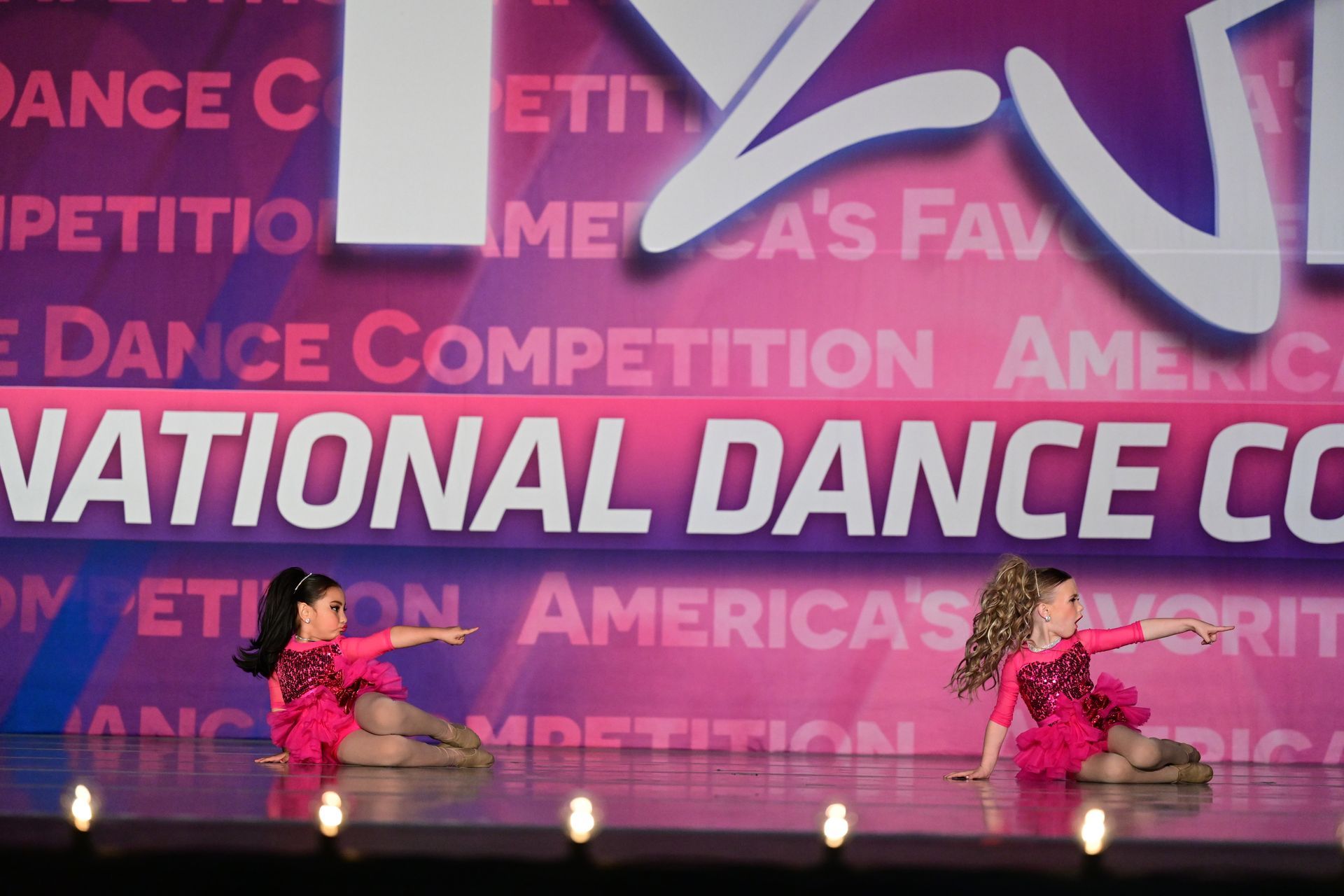 A young girl is wearing a yellow tank top and black pants