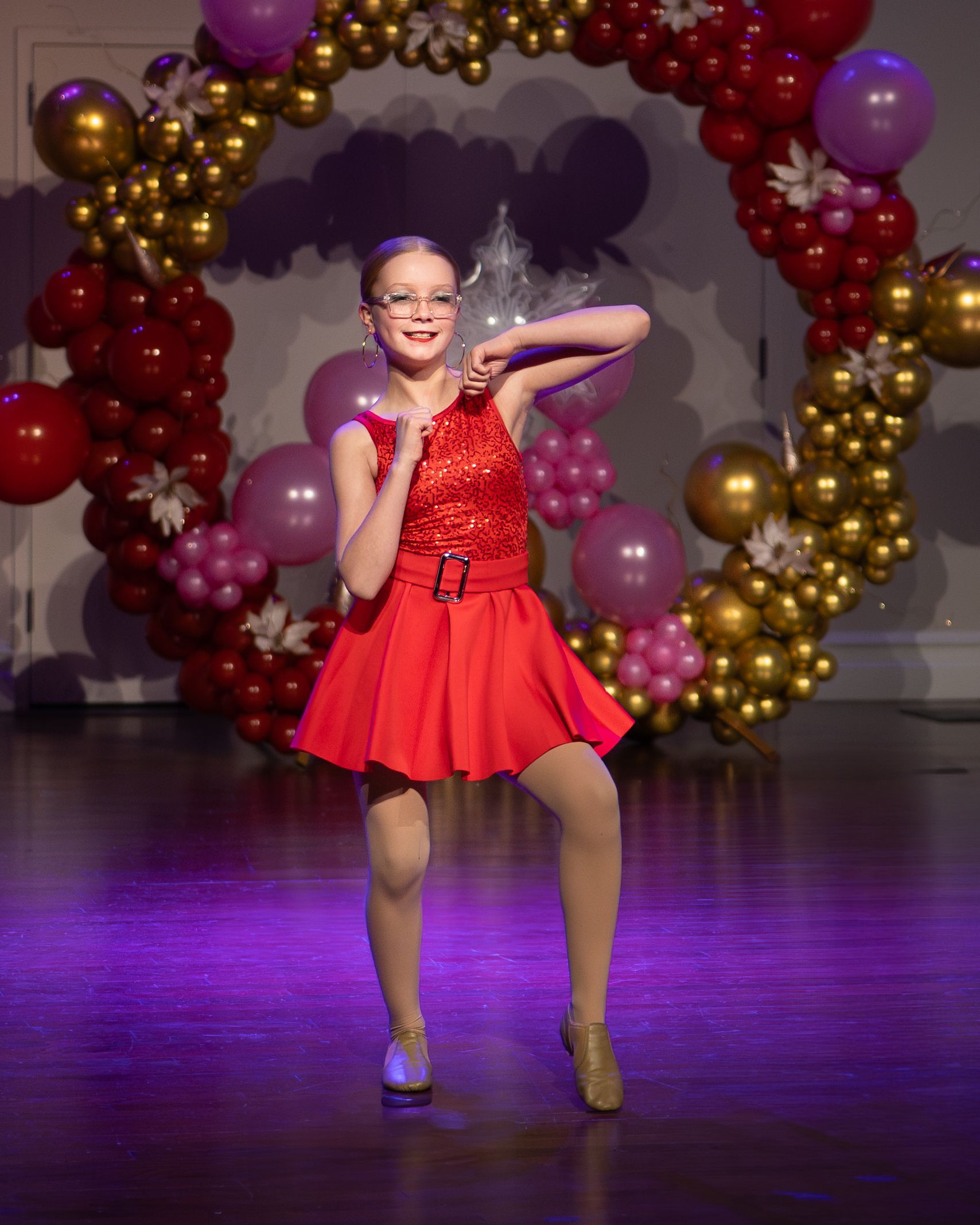 A young girl is wearing a yellow tank top and black pants