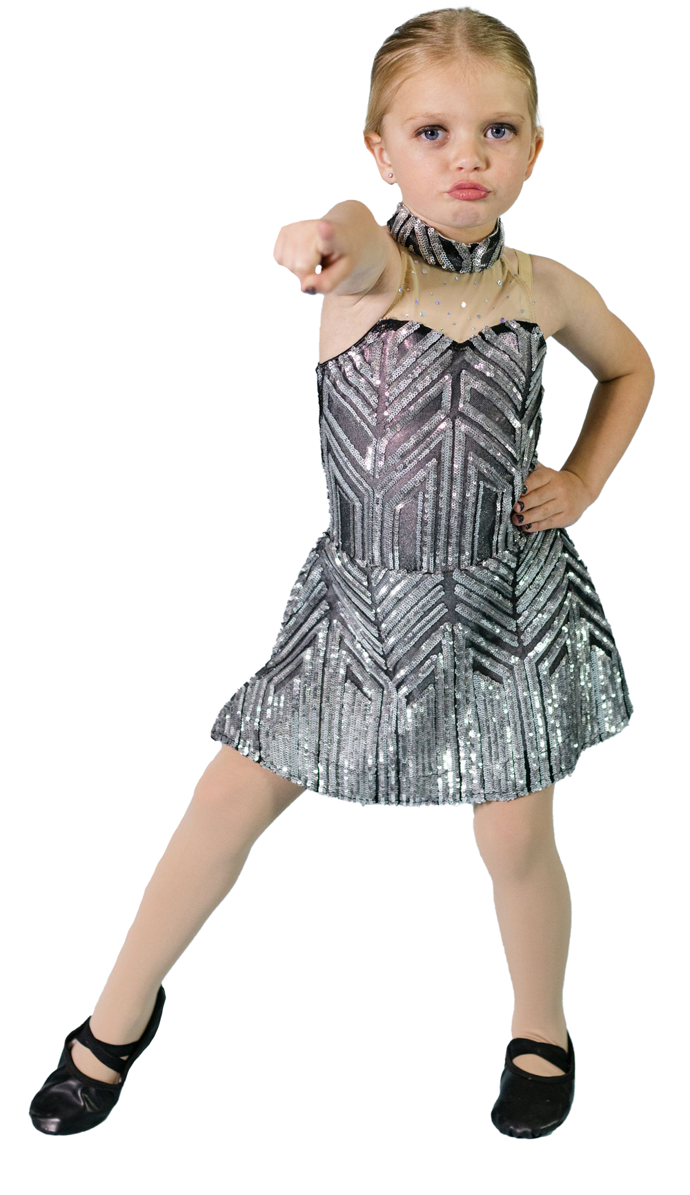 A little girl in a sequined dress is pointing at the camera.