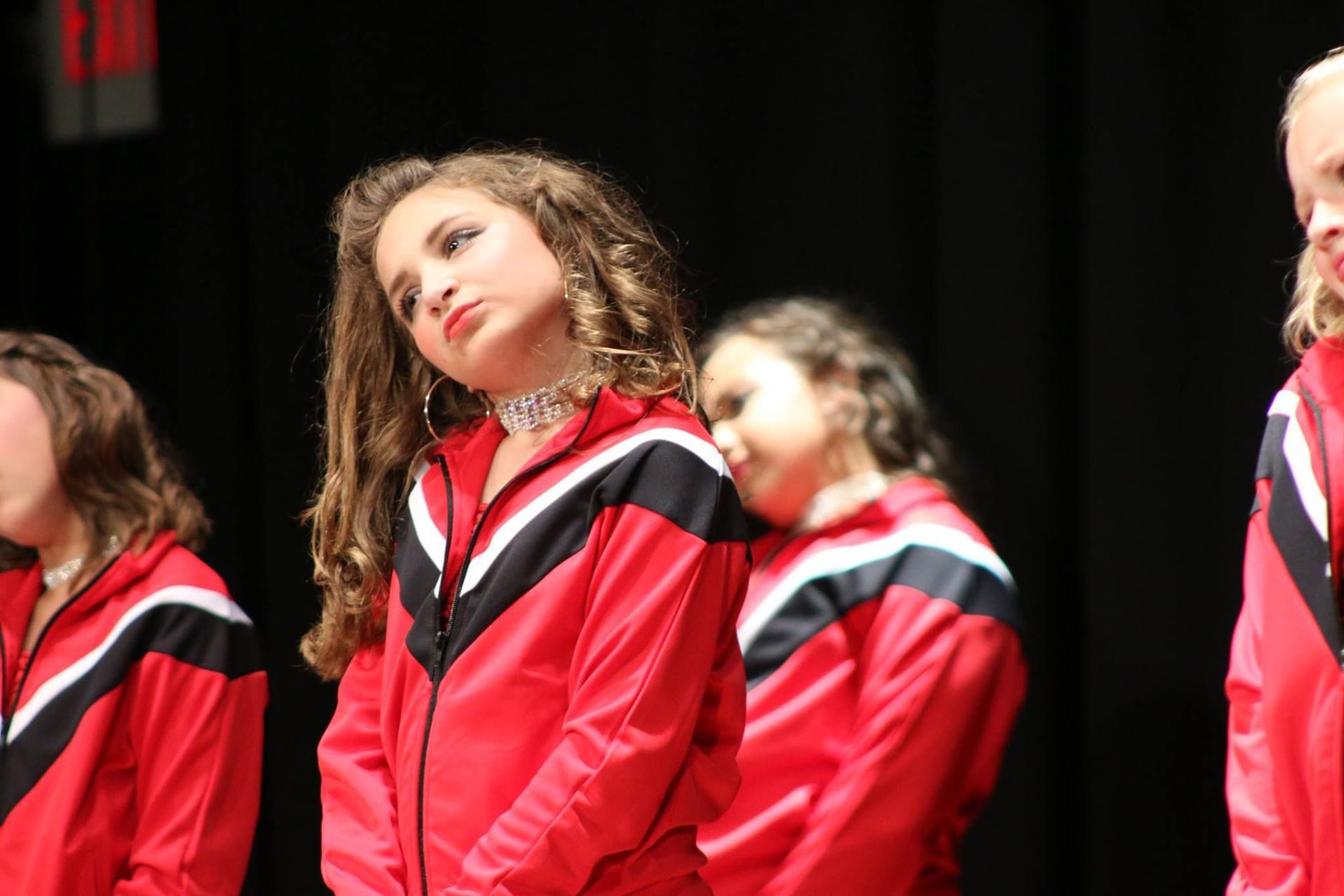 A group of young girls wearing red and black jackets