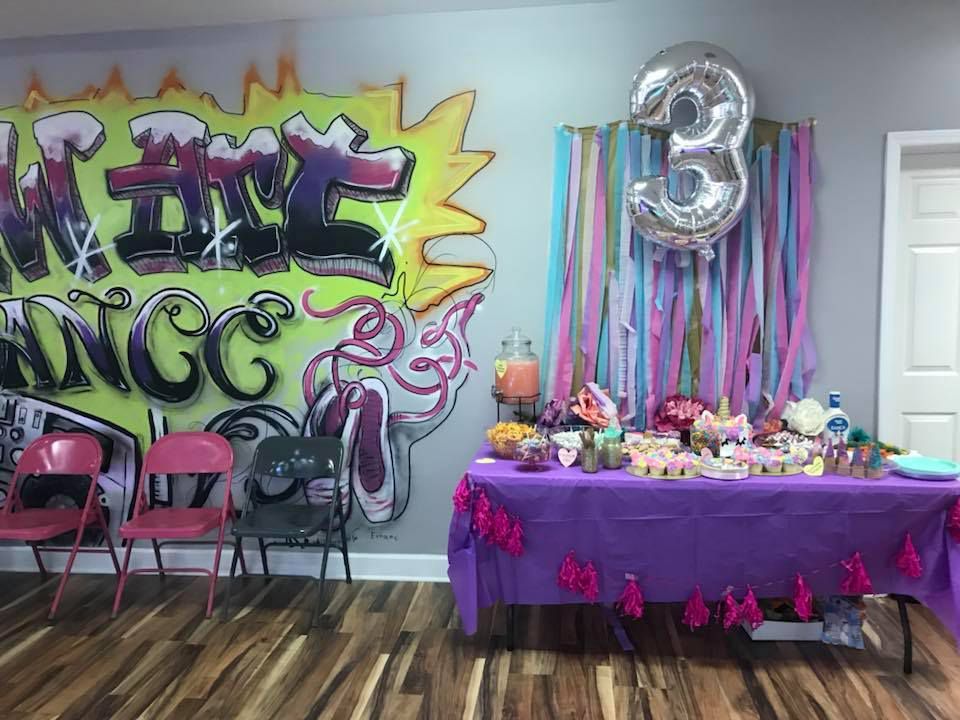 A room with a table and chairs and a wall with graffiti on it.