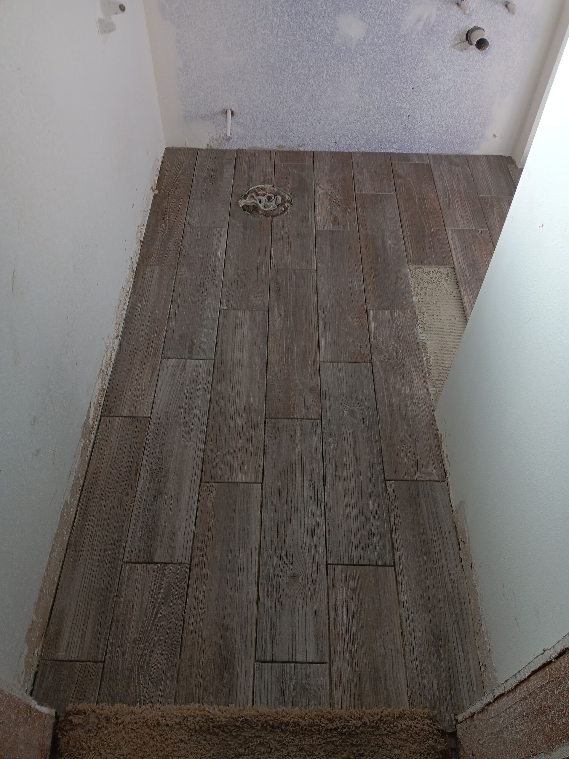 Spacious kitchen with large island and seating, open to living room with stone fireplace.